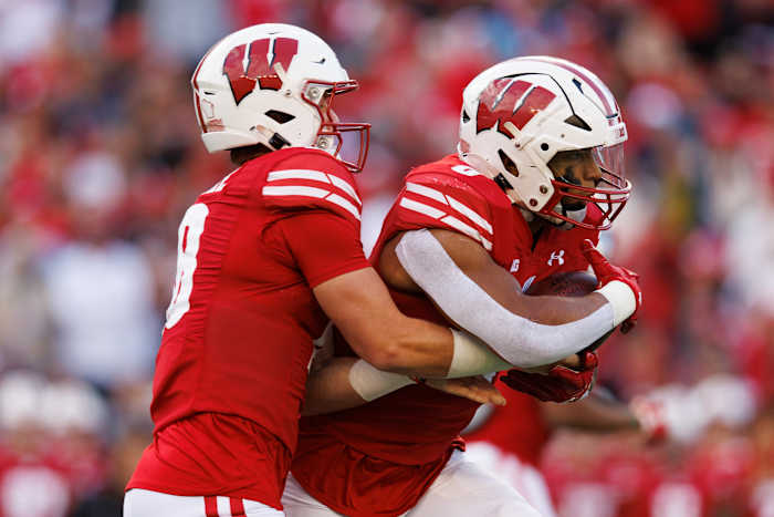 Oct 14, 2023; Madison, Wisconsin, USA; Wisconsin Badgers quarterback Braedyn Locke (18) hands the football off to running back Braelon Allen (0) during the third quarter against the Iowa Hawkeyes at Camp Randall Stadium. Mandatory Credit: Jeff Hanisch-USA TODAY Sports